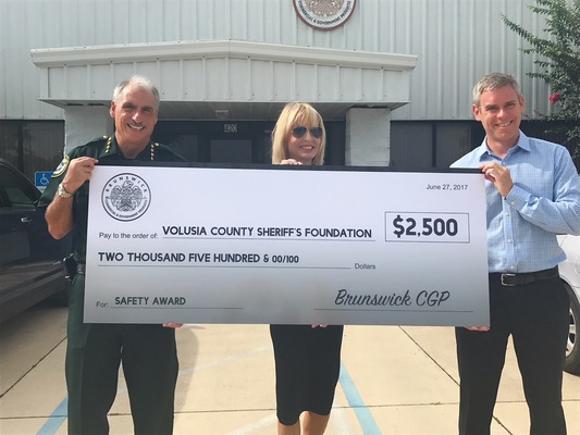 Nick Stickler, President of Brunswick Commercial & Government Products, presents a check for the Volusia County Sheriff’s Foundation to Sheriff Mike Chitwood and Edith Shelley, Chairman of the Foundation.